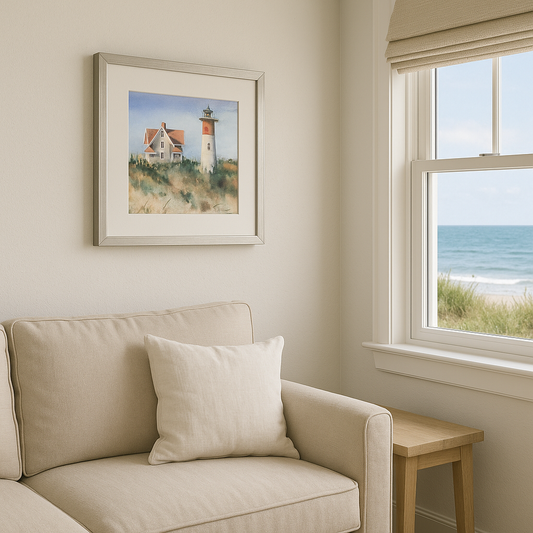 Living room with beige sofa, framed artwork of a lighthouse, and a window overlooking the ocean.