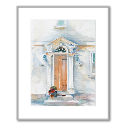 Framed artwork of a watercolor painting of a house exterior with a front door.